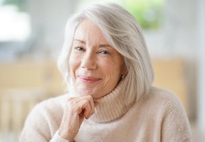 Smiling older woman with a layered, sideswept haircut and fringe
